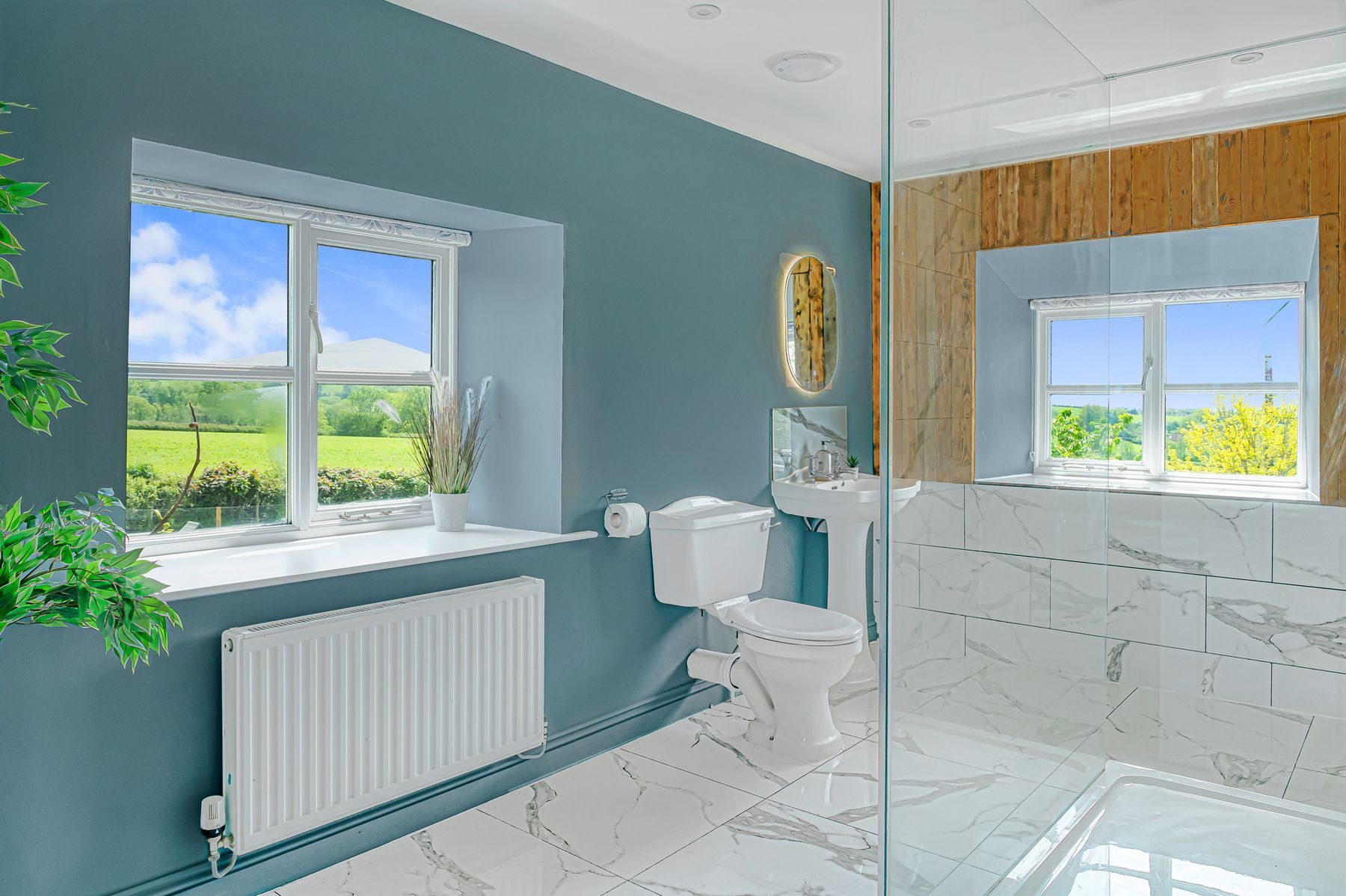 The master ensuite in dark teal with marble shower