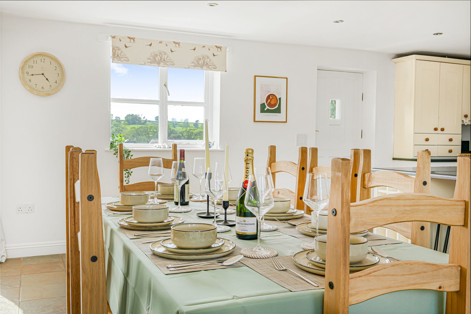 The long oak dining table at Lower Wood Farmhouse set for twelve, with the AGA visible at the end of the room