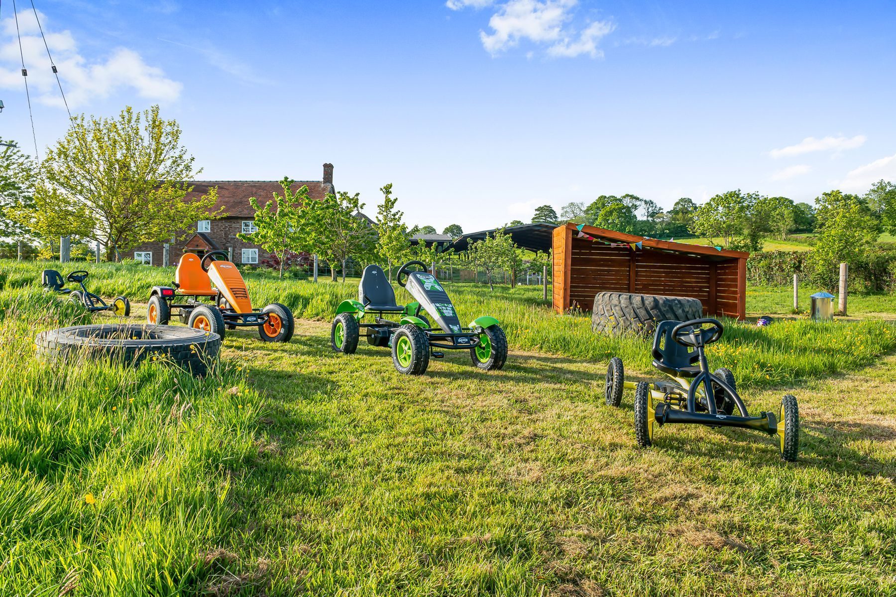 The pedal karts lined up in front of the farmhouse