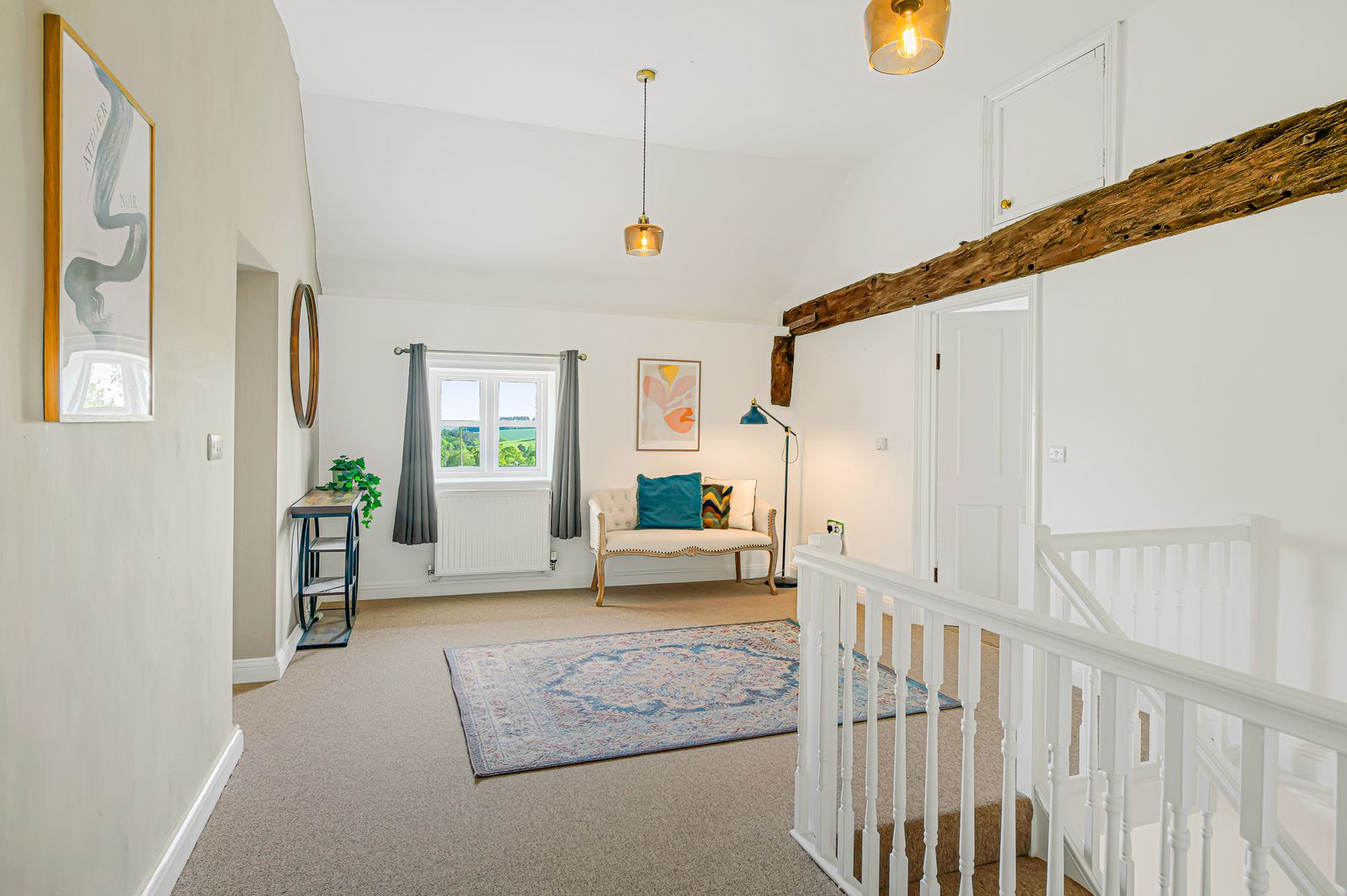The upstairs landing with antique chaise and framed art