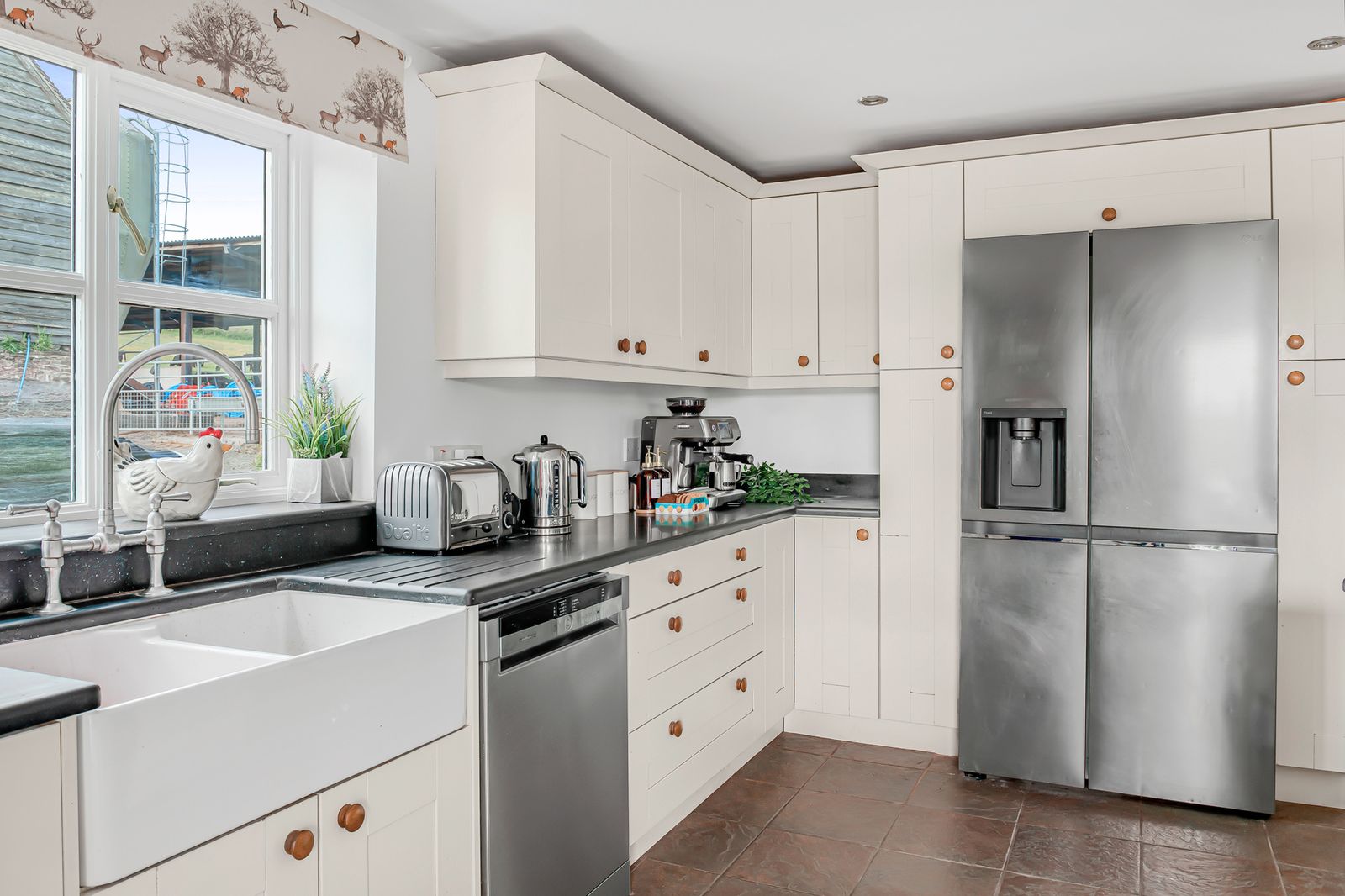 The utility kitchen with farmhouse sink, dishwasher and American fridge-freezer